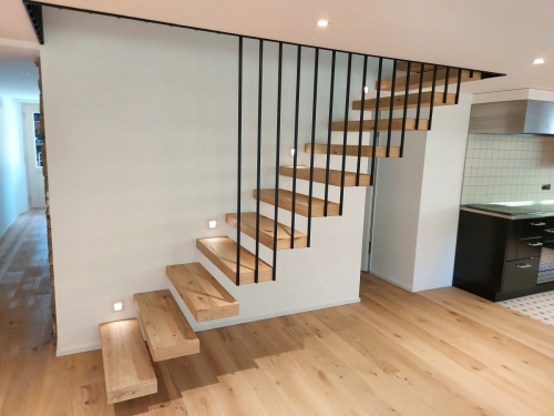 Escalier suspendu en métal et bois, garde-corps/paroi en métal et marches en parquet assemblé