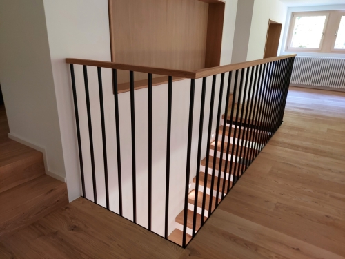 Escalier suspendu en métal et bois, garde-corps/paroi en métal et marches en parquet assemblé