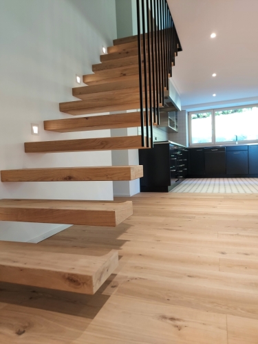 Escalier suspendu en métal et bois, garde-corps/paroi en métal et marches en parquet assemblé