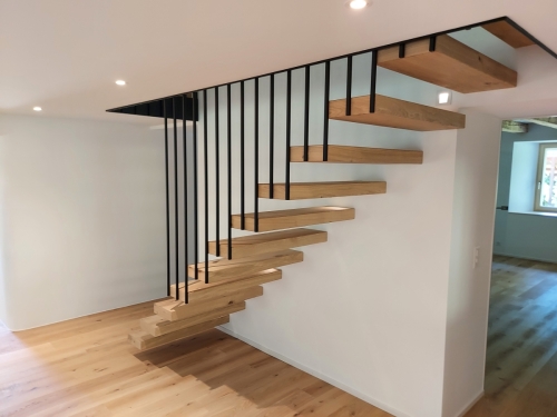 Escalier suspendu en métal et bois, garde-corps/paroi en métal et marches en parquet assemblé