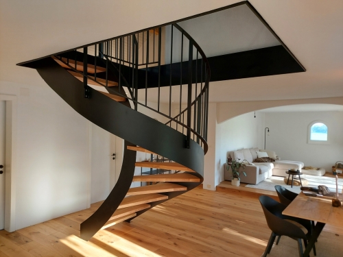 Escalier bois et métal, demi tournant avec limons métallique cintrés, garde-corps à barreaudage et marches en chêne massif