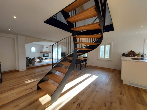 Escalier bois et métal, demi tournant avec limons métallique cintrés, garde-corps à barreaudage et marches en chêne massif