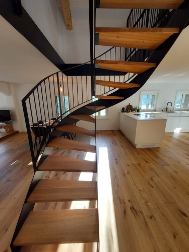 Escalier bois et métal, demi tournant avec limons métallique cintrés, garde-corps à barreaudage et marches en chêne massif